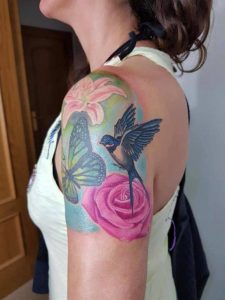 Sarm Heslop Colour Tattoo on Left Shoulder of Rose, Lily, Butterfly and Hummingbird
